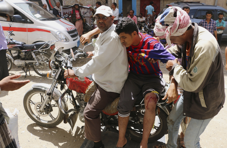 Men on a motorbike carry a man who was injured during clashes between tribal fighters loyal to the exiled President Abed Rabbo Mansour Hadi and Shiite rebels known as Houthis in the western city of Taiz, Yemen, on Sunday (AP photo)